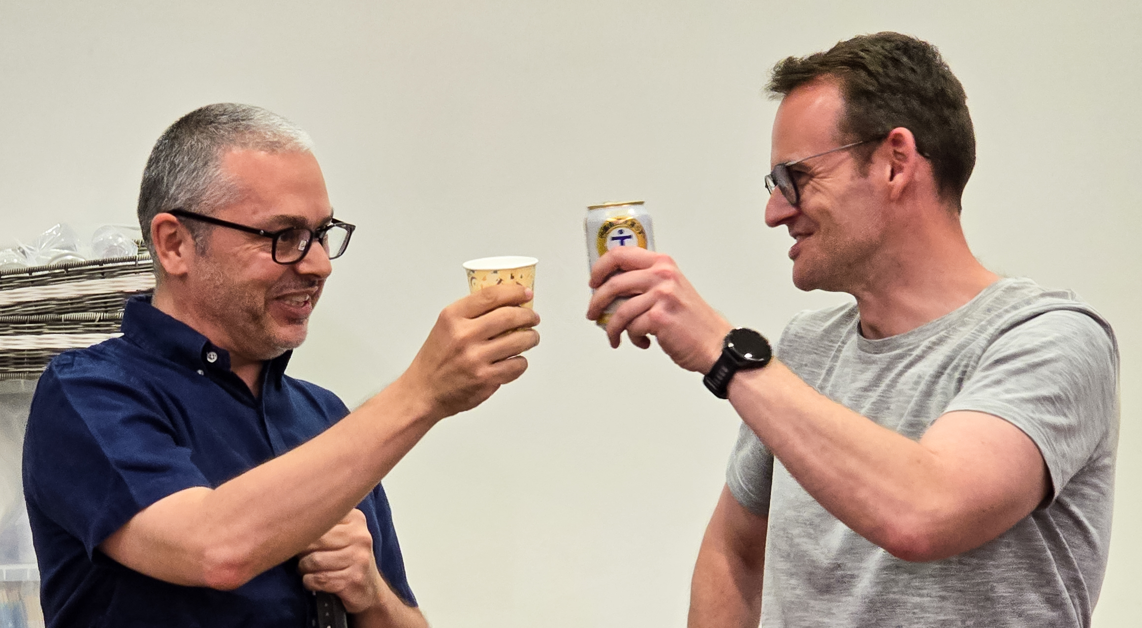 Karim Trabelsi und Florian Bernlochner stoßen mit einem Getränk an.
